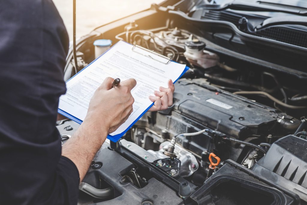 Technician performing a GMC vehicle inspection at Rossi GMC