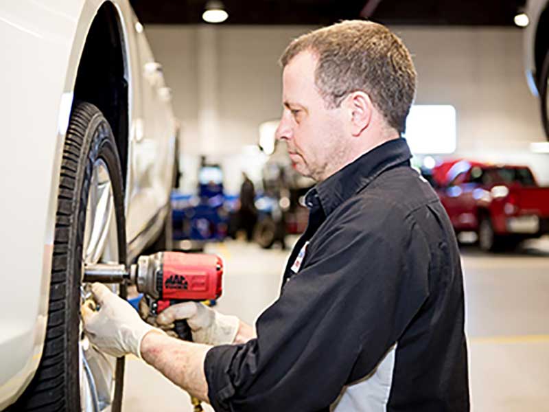 A service tech at #D replacing tires
